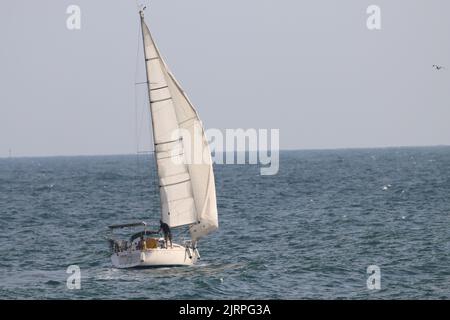 Una barca a vela bianca in mare aperto Foto Stock