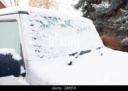 Neve e ghiaccio che ricoprono il parabrezza o il parabrezza di un'auto, parcheggiati su un vialetto di accesso all'esterno di una casa, nel Regno Unito Foto Stock