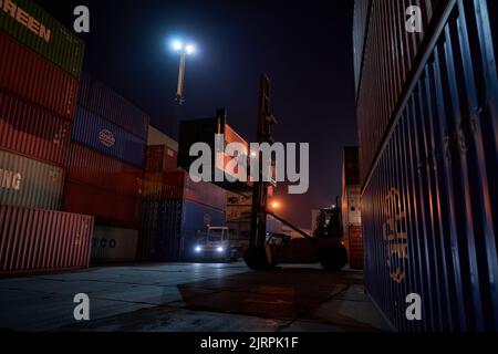 Odessa, Ucraina SIRCA 2019: Raggiungere il raccoglitore durante il funzionamento. Caricatore di contenitori con impilatore a scorrimento durante il lavoro notturno. Terminale contenitore porta industriale Foto Stock