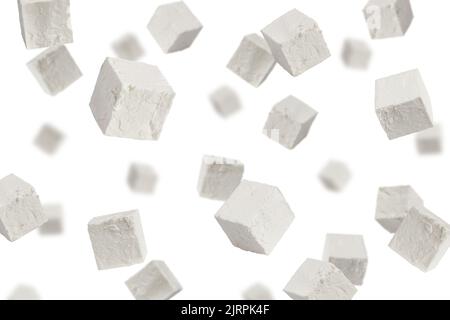 Feta cadente, cubetti di formaggio greco, isolato su sfondo bianco, fuoco selettivo Foto Stock