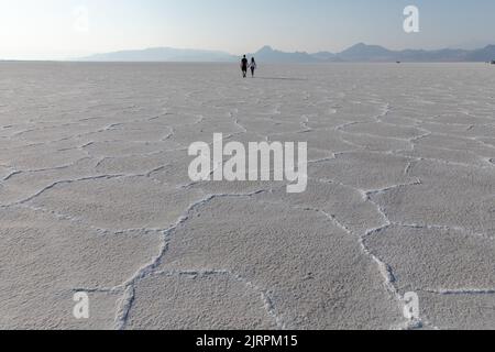 Giovane coppia che tiene le mani a camminare su Bonneville Salt Flats nello Utah Foto Stock