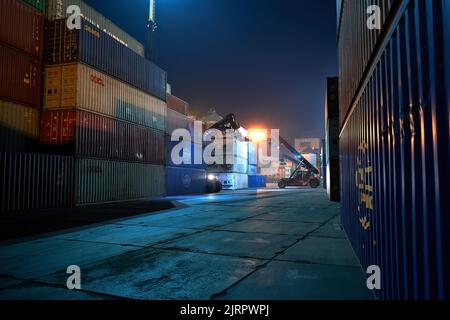 Odessa, Ucraina SIRCA 2019: Funzionamento del terminal container di notte. Scarico della nave container di notte. Pile di contenitori al terminal Foto Stock