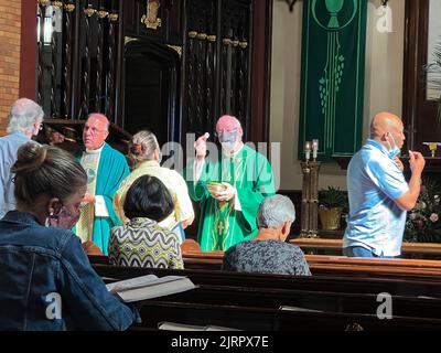 Il sacerdote offre la Santa comunione durante una Messa cattolica a Brooklyn, New York. Foto Stock