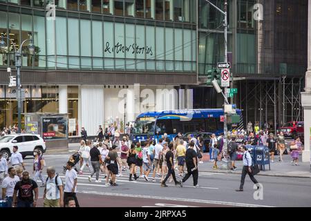 42nd Street a 5th Avenue è sempre affollata con pedoni sul marciapiede e strada e traffico Foto Stock