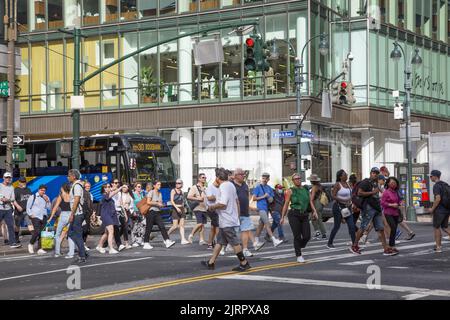 42nd Street a 5th Avenue è sempre affollata con pedoni sul marciapiede e strada e traffico Foto Stock