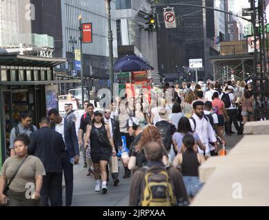 42nd Street a 5th Avenue è sempre affollata con pedoni sul marciapiede e strada e traffico Foto Stock