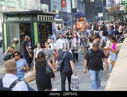 42nd Street a 5th Avenue è sempre affollata con pedoni sul marciapiede e strada e traffico Foto Stock