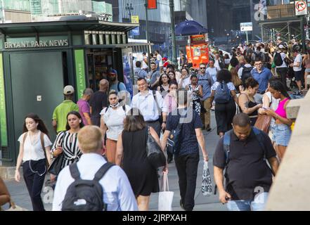 42nd Street a 5th Avenue è sempre affollata con pedoni sul marciapiede e strada e traffico Foto Stock