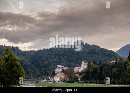 Foto del paesaggio della riva del fiume Savinja con il castello di celje sullo sfondo. Celje è la quarta città più grande della Slovenia. È una regi Foto Stock