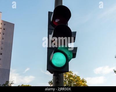 Semaforo verde brillante per i conducenti di auto. Questo segnale luminoso accanto alla strada indica che il traffico può muoversi. Sicurezza nelle strade tedesche. Foto Stock