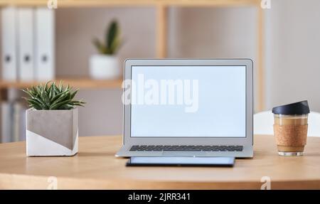 Laptop, caffè e tablet mockup sulla scrivania dell'ufficio di casa di SEO, UX o digital social media marketing e pubblicità freelance. Internet o. Foto Stock