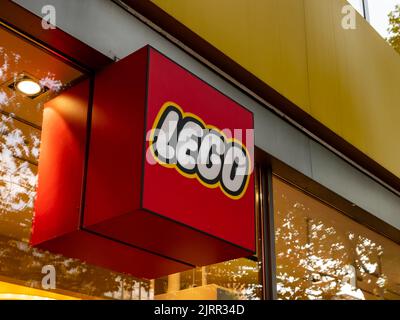 Logo LEGO sulla facciata di un negozio in città. Segno del produttore danese di giocattoli da costruzione in plastica è famoso per i prodotti di alta qualità. Foto Stock