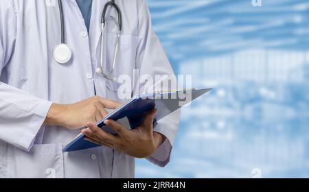 Medico in un uniforme, uno stetoscopio in un corridoio.Man ospedale che tiene documento archivio sanità concept.copy spazio Foto Stock
