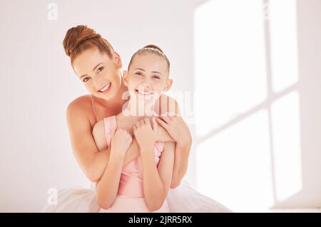 Balletto ritratto insegnante e bambino abbracciare in studio con felice sorriso e sostegno dopo l'allenamento. Felice donna e ragazza dopo aver imparato la danza e la creatività Foto Stock