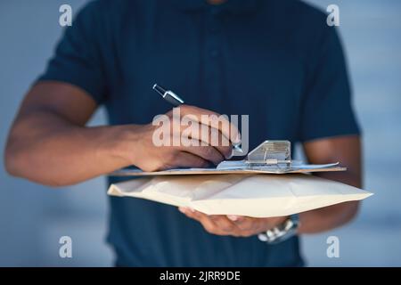 Consegna puntuale del pacco sempre. Un corriere non identificabile che compila la documentazione mentre si è in consegna. Foto Stock