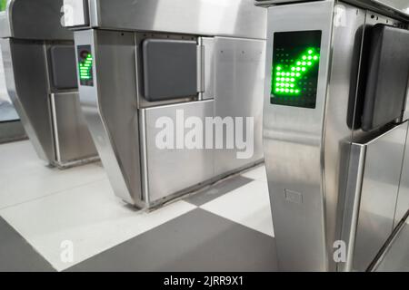 Cancello d'ingresso con freccia verde direzione segno sulla stazione della metropolitana Foto Stock