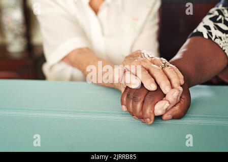 Sentitevi meglio, insieme. Una donna anziana che tiene le mani dei suoi amici nel comfort. Foto Stock