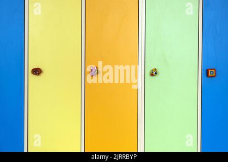 Primo piano delle porte luminose e colorate armadietti con animali divertenti come pomelli porta nella scuola di cura di giorno Foto Stock
