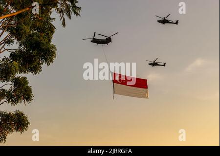 Singapore Flag è volato da un elicottero Chinook, accompagnato da due elicotteri Apache nel National Day 2022 di Singapore Foto Stock