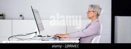 Cattiva postura seduta nella sedia dell'ufficio alla scrivania del computer Foto Stock