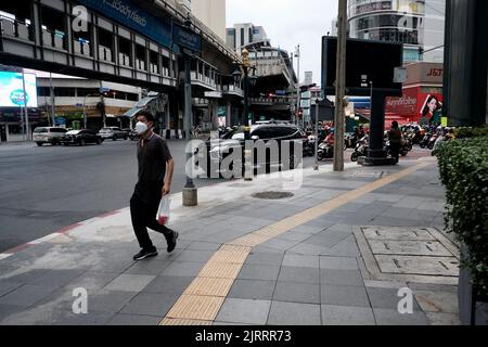 Uomo che cammina giù Soi Asoke aka Asok montri Road aka Ratchadaphisek anello interno strada Bangkok Thailandia Foto Stock