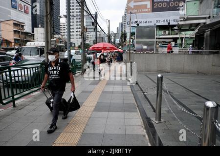 Uomo che cammina giù Soi Asoke aka Asok montri Road aka Ratchadaphisek anello interno strada Bangkok Thailandia Foto Stock