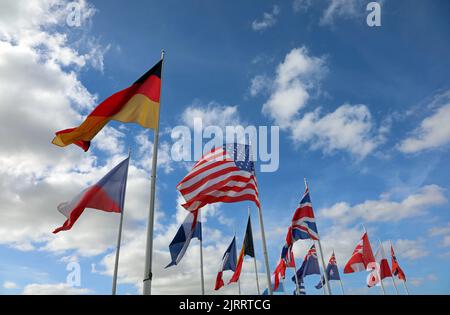 molte bandiere internazionali germania usa regno unito e altri su cielo blu e nuvole bianche Foto Stock