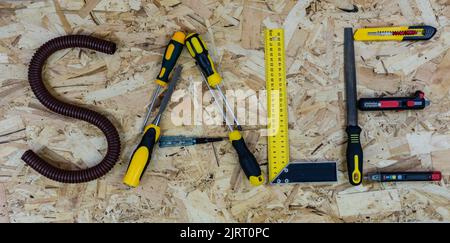 La parola VENDITA composta da lettere raccolte da strumenti di costruzione. Sfondo del pannello di costruzione OSB. Foto Stock