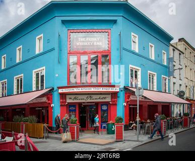 CORK, IRLANDA. APRILE 19, 2022. Il Frisky Whiskey Bar. Centro storico. Piccola strada con architettura tradizionale e gente che cammina intorno. Primavera i Foto Stock