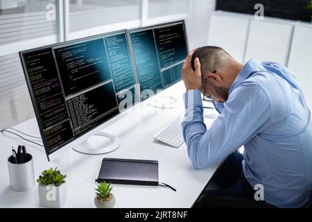 Infelice Sad Developer Programmer Man in stress Coding Software su computer Foto Stock