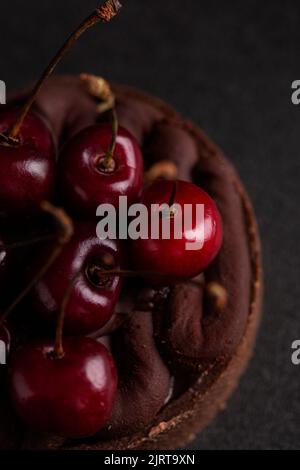 Crostata al cioccolato con ganache decorata con ciliegia fresca Foto Stock
