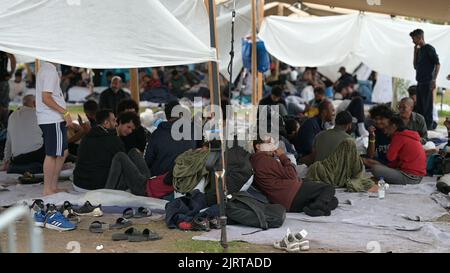 Ter Apel, Paesi Bassi. 26th ago, 2022. I richiedenti asilo si trovano nelle vicinanze del centro nazionale di asilo Ter Apel. Médecins Sans Frontières si occupa per la prima volta anche delle persone nei Paesi Bassi, presso il centro nazionale per l'asilo Ter Apel, dove centinaia di richiedenti asilo hanno dormito all'aperto per settimane nella zona circostante l'impianto, dopo il confine con la bassa Sassonia, per mancanza di spazio per dormire presso la struttura. Credit: Lars Klemmer/dpa/Alamy Live News Foto Stock