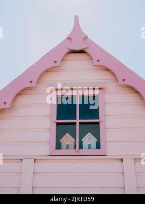 Capanna da spiaggia dipinta di rosa pastello e cielo blu da vicino Foto Stock