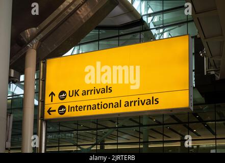 Un grande cartello che indica le indicazioni per il Regno Unito e gli arrivi internazionali all'Aeroporto Heathrow di Londra, Terminal due. Foto Stock