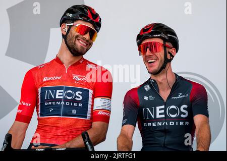 Meiningen, Germania. 26th ago, 2022. Ciclismo: Tour della Germania, Meiningen - Marburg (200,70 km), tappa 2. Filippo Ganna (l) dall'Italia di Ineos Grenadiers nella maglia rossa del leader assoluto si trova accanto al suo compagno di squadra Adam Yates dalla Gran Bretagna sul palco per accedere all'inizio della seconda tappa. Credit: Daniel Vogl/dpa/Alamy Live News Foto Stock