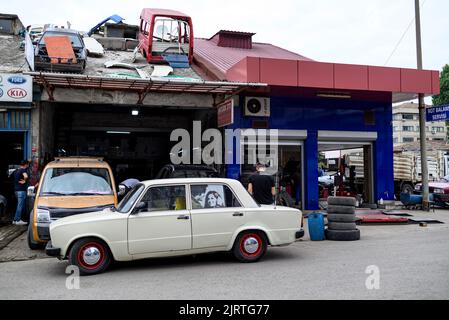 Vecchia macchina russa sovietica LADA 2105 con foto di attori turchi sul finestrino è in piedi vicino ufficio di riparazione a Trabzon, Turchia Foto Stock