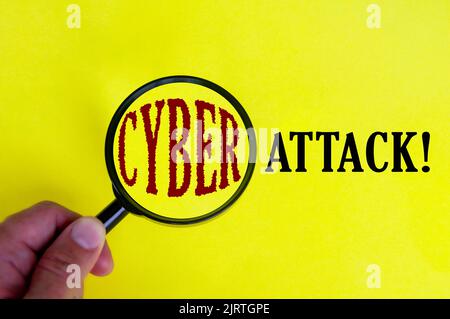 Testo Cyber Attack sulla copertina gialla con lente d'ingrandimento. Concetto di sicurezza Internet. Foto Stock