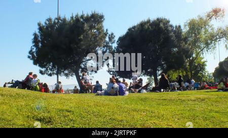 Persone pic-nic sul prato in riva al mare. Gruppo di persone sedute su sedie pieghevoli in erba. Istanbul, Turchia, maggio 21 2022 Foto Stock