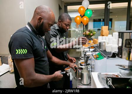 Città del Capo, Sudafrica - 26 aprile 2022: Barista maschile africano che prepara un caffè in un bar Foto Stock