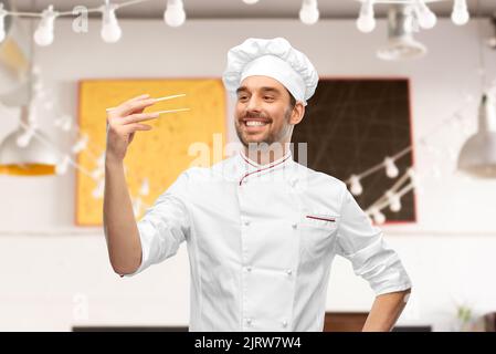 buon cuoco maschio sorridente con i chopsticks Foto Stock