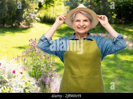 ritratto di donna anziana sorridente in grembiule da giardino Foto Stock