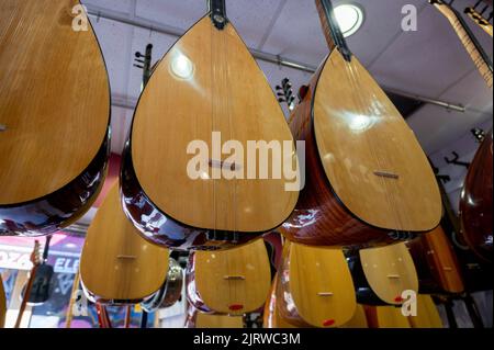 Istanbul, Turchia 2022. File di strumenti a corda etnica turca saz e baglama in un negozio in vendita al Grand Bazaar Foto Stock