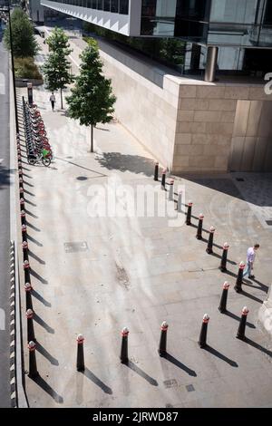 Una vista aerea dei pedoni che camminano lungo il marciapiede e che passano i paletti nella City of London, nota anche come Square Mile, il quartiere finanziario della capitale, il 26th agosto 2022, a Londra, Inghilterra. Foto Stock