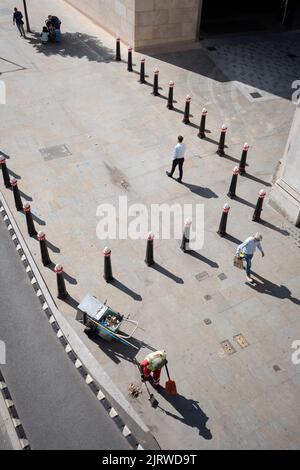 Una vista aerea di un appaltatore di strada che rimuove la lettiera lungo il marciapiede e intorno a palangari nella City of London, nota anche come Square Mile, il quartiere finanziario della capitale, il 26th agosto 2022, a Londra, Inghilterra. Foto Stock