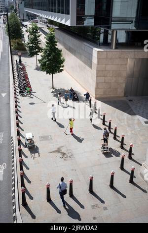 Una vista aerea di un appaltatore di strada che rimuove la lettiera lungo il marciapiede e intorno a palangari nella City of London, nota anche come Square Mile, il quartiere finanziario della capitale, il 26th agosto 2022, a Londra, Inghilterra. Foto Stock