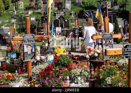 Lviv, Ucraina. 26th ago, 2022. Una donna prega presso la tomba di un soldato caduto, ucciso dall'esercito russo durante l'invasione del 2022 nella città vecchia di Lviv, Ucraina sul cimitero di Lychakiv, mentre la guerra con la Russia suppone 6 il 26 agosto 2022. La città di Lviv ha selezionato una fessura separata di terra nel cimitero per i soldati caduti nella lotta con la Russia, i militari sono ampiamente considerati come eroi nazionali. (Foto di Dominika Zarzycka/Sipa USA) Credit: Sipa USA/Alamy Live News Foto Stock