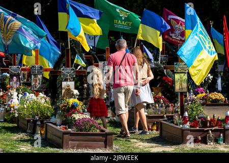 Lviv, Ucraina. 26th ago, 2022. Una famiglia arriva per rispettare le tombe di soldati caduti, uccisi dall'esercito russo durante l'invasione del 2022 nella città vecchia di Lviv, in Ucraina, nel cimitero di Lychakiv, mentre la guerra con la Russia suppone 6 il 26 agosto 2022. La città di Lviv ha selezionato una fessura separata di terra nel cimitero per i soldati caduti nella lotta con la Russia, i militari sono ampiamente considerati come eroi nazionali. (Foto di Dominika Zarzycka/Sipa USA) Credit: Sipa USA/Alamy Live News Foto Stock