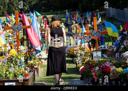 Lviv, Ucraina. 26th ago, 2022. Una donna rispetta le tombe di soldati caduti, uccisi dall'esercito russo durante l'invasione del 2022 nella città vecchia di Lviv, Ucraina, nel cimitero di Lychakiv, mentre la guerra con la Russia sopprimerà 6 il 26 agosto 2022. La città di Lviv ha selezionato una fessura separata di terra nel cimitero per i soldati caduti nella lotta con la Russia, i militari sono ampiamente considerati come eroi nazionali. (Foto di Dominika Zarzycka/Sipa USA) Credit: Sipa USA/Alamy Live News Foto Stock