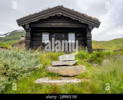Vecchie cabine in legno nel villaggio storico di Eidsbugarden, alla testa del lago Bygdin Norvegia Foto Stock