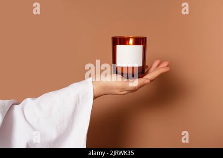 Coperto con una mano di panno bianco che tiene una candela Foto Stock